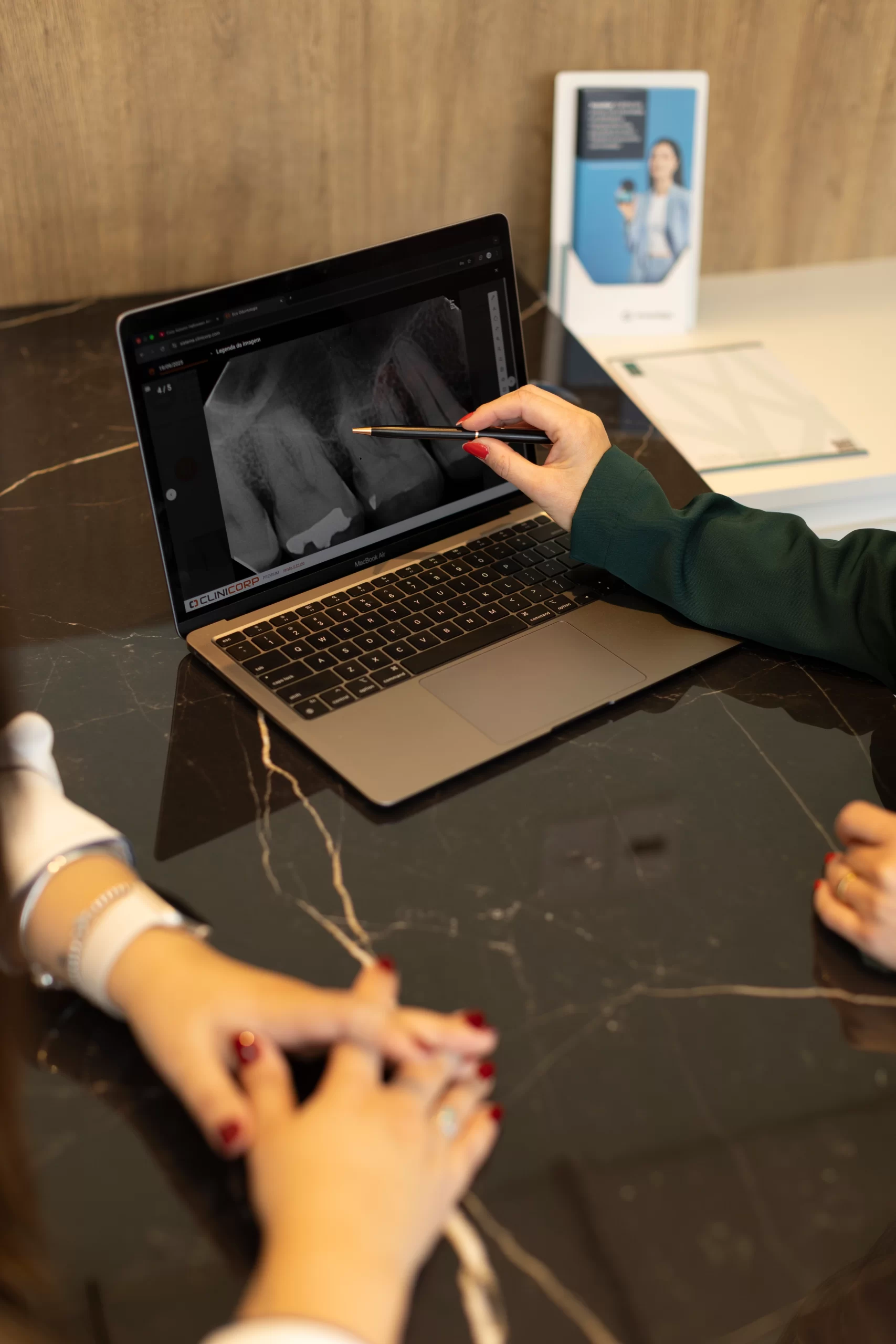 Na clínica Eco Odontologia, uma dentista especializada realiza um diagnóstico detalhado para tratamento de canal utilizando exames digitais de alta precisão em um notebook. A imagem destaca o uso de tecnologia moderna e instrumentação avançada no Eco Medical Center, em Curitiba, para identificar cáries profundas ou inflamações na polpa dentária com total clareza. O planejamento digital e o atendimento acolhedor reforçam o compromisso da clínica em preservar o dente natural, eliminando a dor e devolvendo a funcionalidade do sorriso com segurança, agilidade e máximo conforto para o paciente.