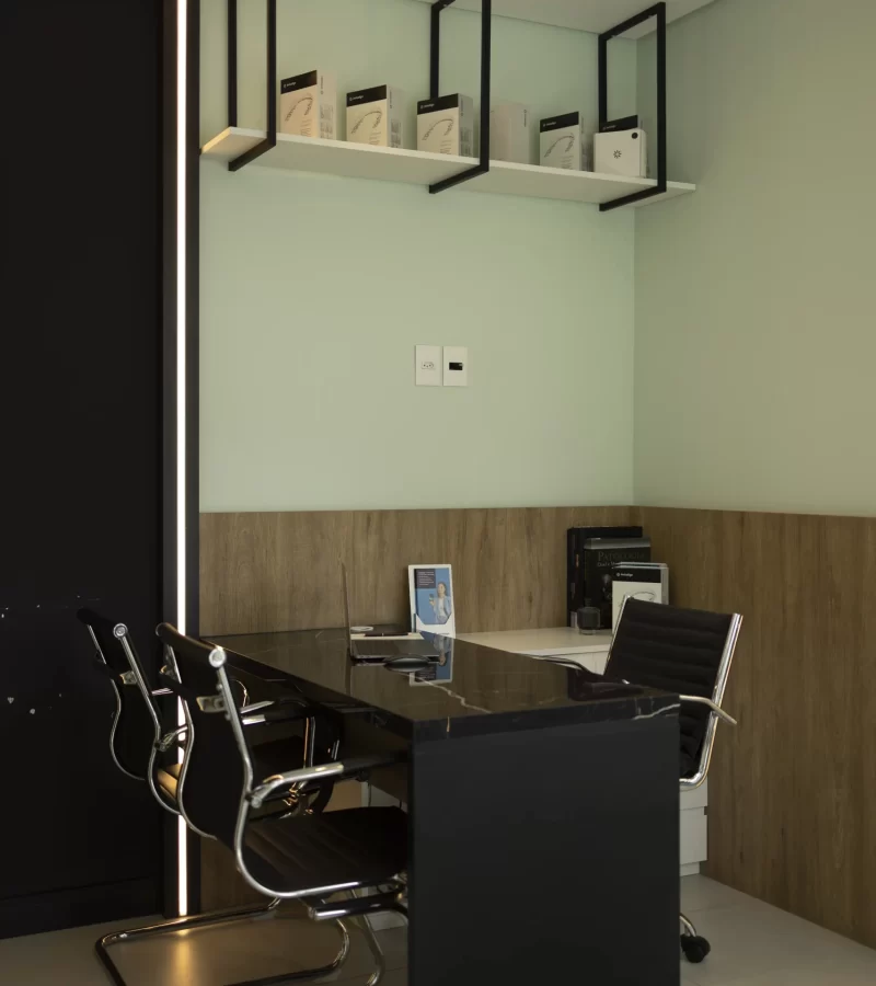 A sala de atendimento da Eco Odontologia apresenta um ambiente moderno e sofisticado, com mobiliário de alto padrão e design minimalista, ideal para a realização de consultas de planejamento e orientações personalizadas. O espaço reflete o compromisso da clínica com a organização, a privacidade e a excelência em infraestrutura, oferecendo um local acolhedor onde a tecnologia e o cuidado humanizado se encontram para garantir que cada paciente receba um plano de tratamento exclusivo, transparente e focado nos melhores resultados para sua saúde bucal.